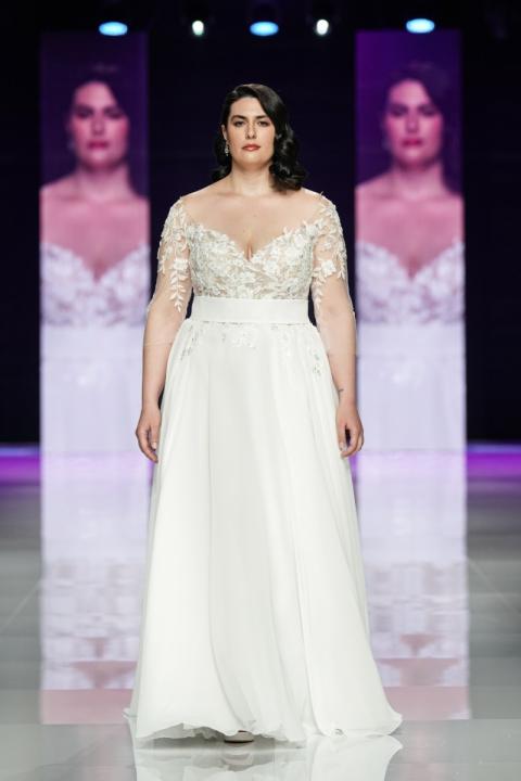 Abito da sposa curvy Camilla in passerella, maniche lunghe in pizzo, scollo a cuore.