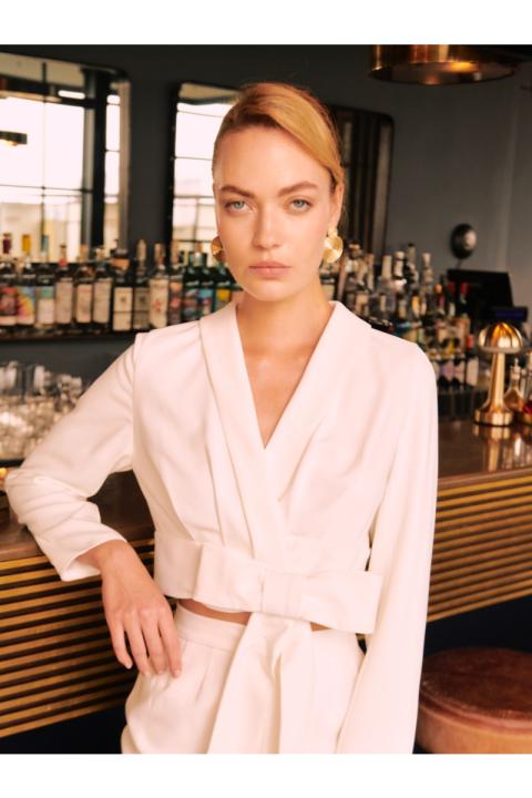 Modella in abito bianco Siena Sposae Essential in un bar elegante.