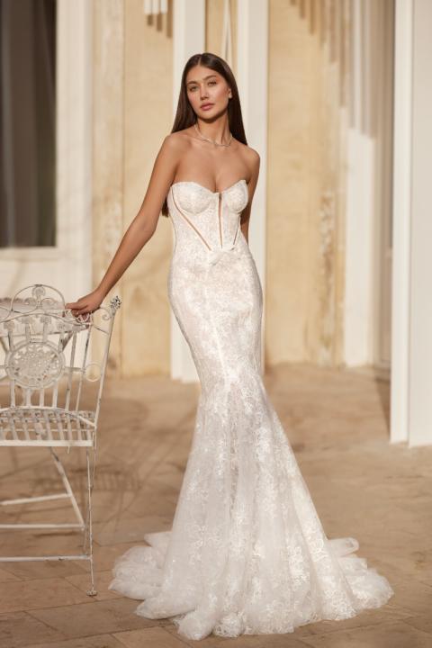 Abito da sposa AGATE di Mark Loren, design elegante in pizzo, sfondo architettonico raffinato.