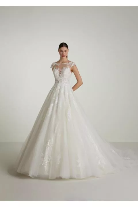 Abito da sposa ANDRADA in pizzo bianco con dettagli floreali e scollo trasparente.