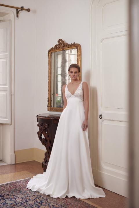 Abito da sposa elegante ANGEL di Mark Loren con scollatura a V, in ambientazione classica con specchio antico.