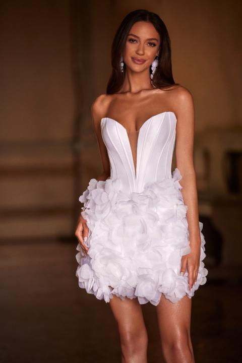 Abito corto bianco senza spalline con gonna a petali, indossato da modella sorridente.