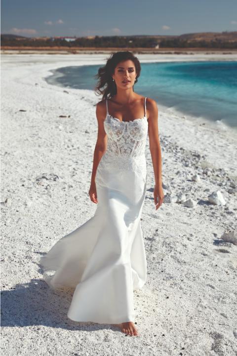 Abito da sposa Miami di Eddy K, donna su spiaggia bianca con mare turchese sullo sfondo.