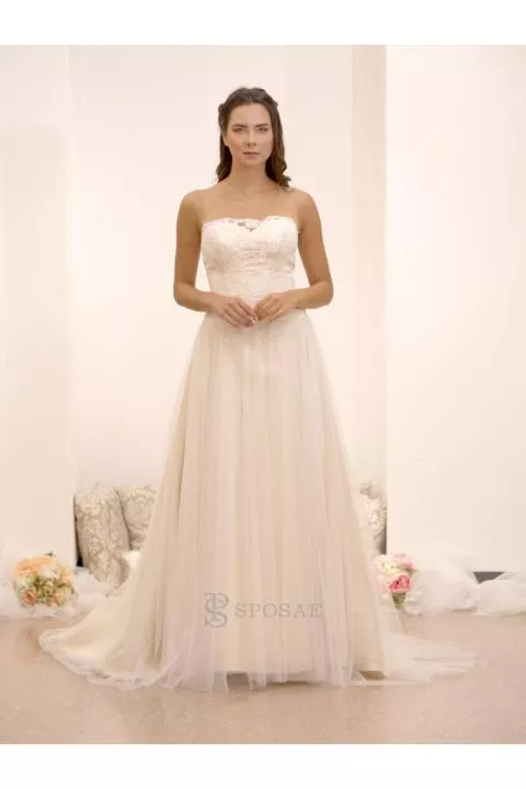 Abito da sposa outlet Isabelle in pizzo e tulle, senza spalline, sfondo chiaro.