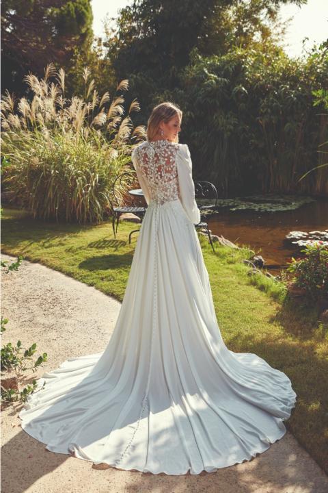 Abito da sposa BETHANY di Eddy K con dettagli in pizzo, sfondo giardino.