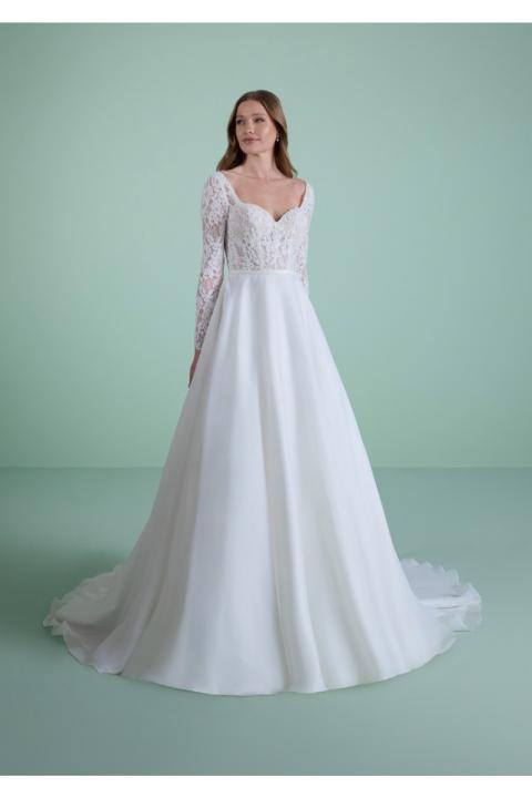 Abito da sposa HYLAS in pizzo bianco con maniche lunghe e gonna ampia su sfondo verde.