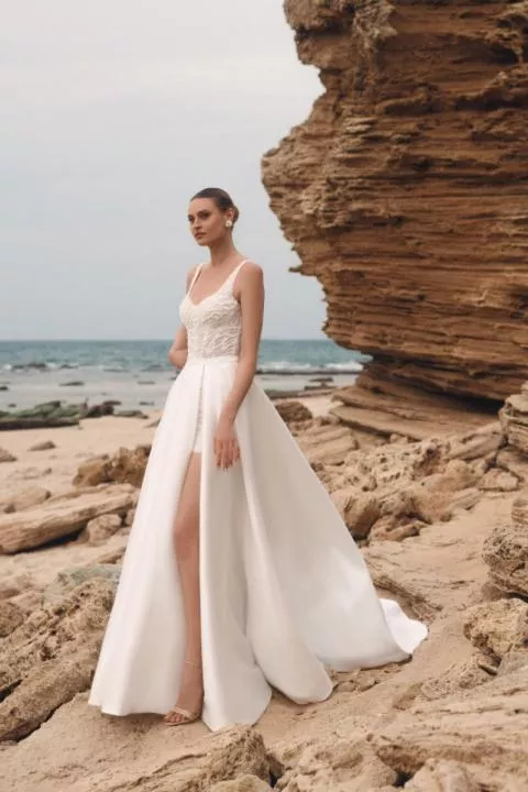 Abito da sposa Lavander di Giovanna Alessandro su spiaggia rocciosa, elegante e moderno.