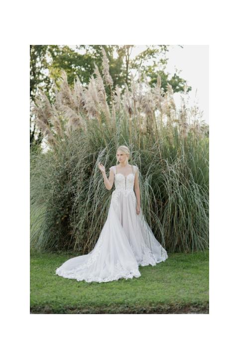 Abito da sposa OFELIA di Sposae Atelier, elegante e romantico, con dettagli in pizzo, ambientato in un giardino verde.