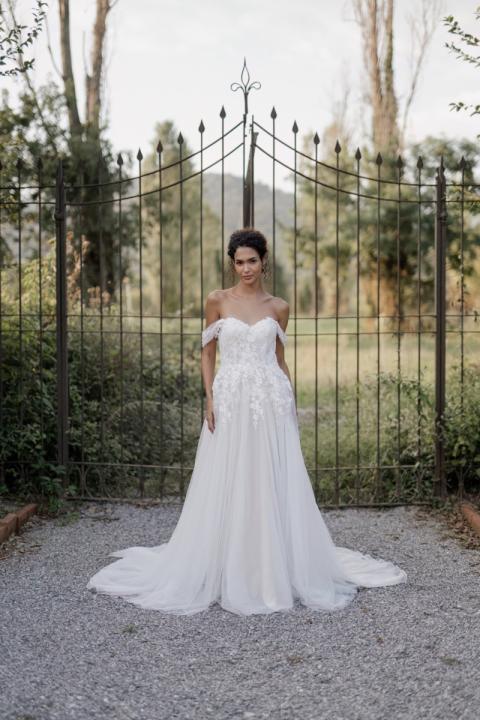 Abito da sposa Deneb Linea Sposae Atelier, stile romantico, sfondo giardino con cancello in ferro battuto.