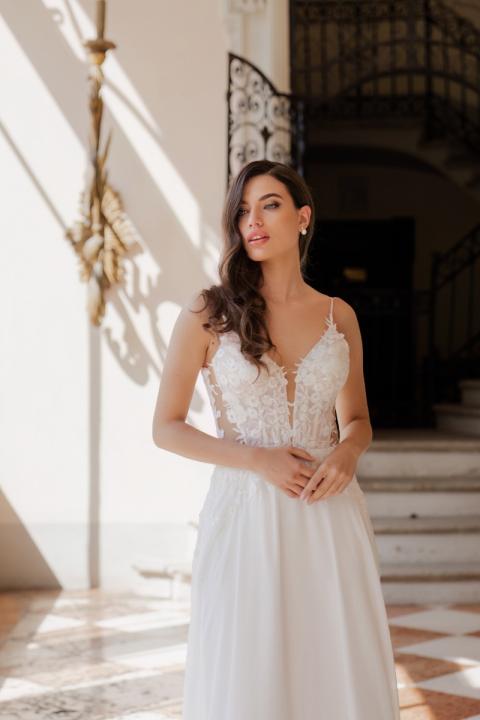 Abito da sposa ANITA di ROMANTICA BY SPOSAE, con dettagli in pizzo, in ambiente elegante.