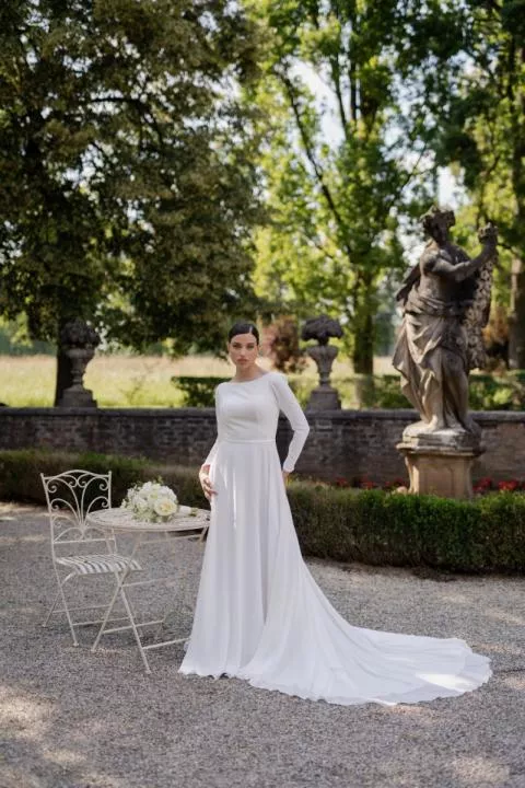 Abito da sposa bianco a maniche lunghe GIUSY - ROMANTICA BY SPOSAE ATELIER in giardino elegante.