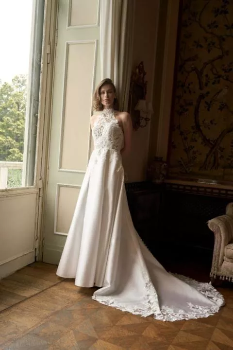 Abito da sposa Orietta, collezione Romantica, con pizzo e strascico, in elegante salone con finestra.