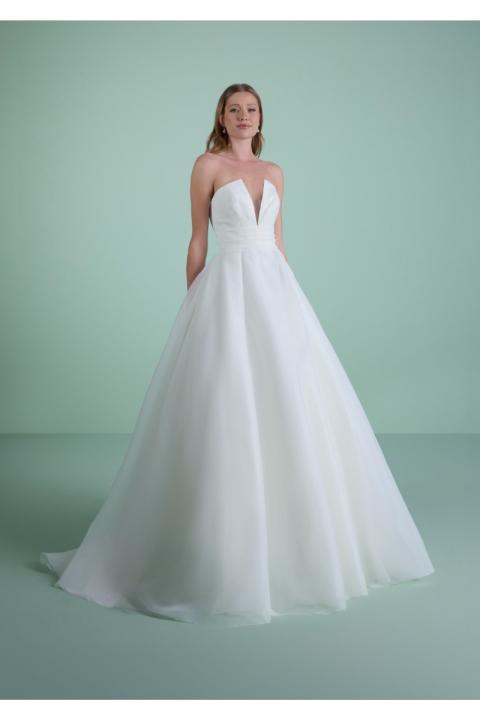 Abito da sposa THYSA bianco con scollo a cuore e gonna ampia su sfondo verde.