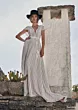 Abito boho in pizzo bianco Moondust di Ariamo, indossato da modella con cappello nero, sfondo rustico.