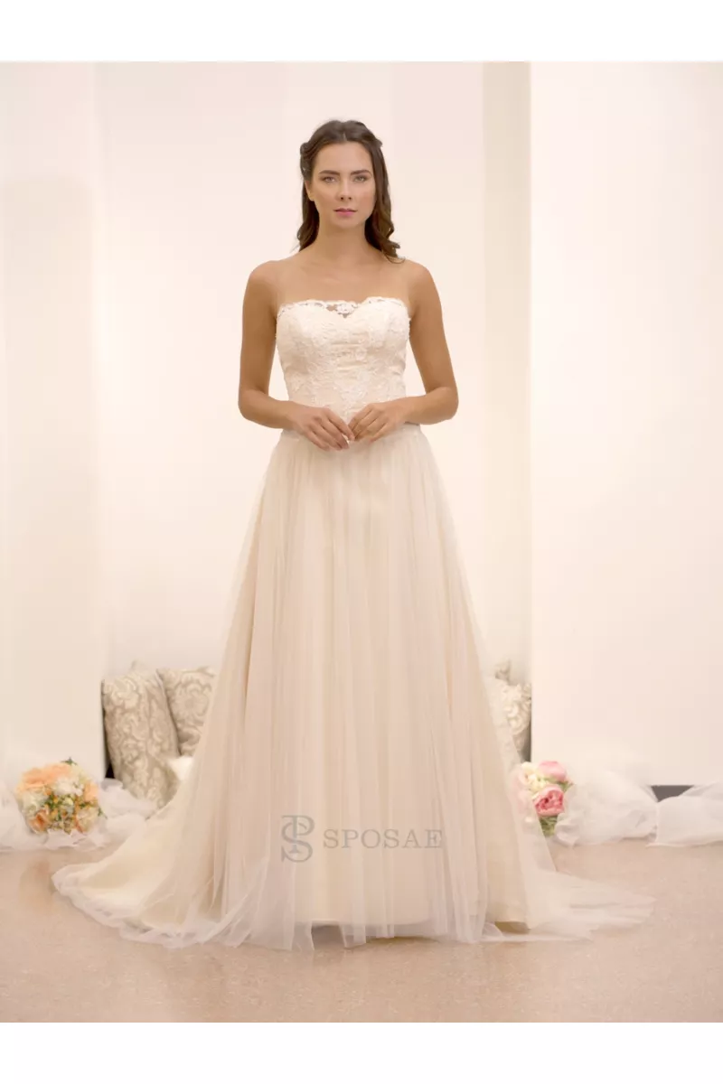 Abito da sposa outlet Isabelle in pizzo e tulle, senza spalline, sfondo chiaro.