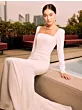 Abito da sposa Mumbai Sposae Essential, bianco, elegante, con scollo quadrato, indossato da una modella su terrazza.