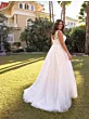 Abito da sposa ANNI - Ladybird in giardino, design elegante con dettagli in pizzo, sfondo villa e palme.