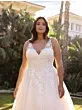 Abito da sposa ANNI Ladybird in pizzo bianco, modello curvy, sfondo giardino.