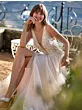 Abito da sposa EMSLEY in pizzo e tulle, donna sorridente seduta all'aperto.