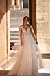 Abito da sposa AVA - DAMA in pizzo e tulle, con scollo a V, maniche lunghe trasparenti, in ambientazione elegante.