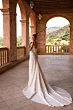 Abito da sposa CHARMONY DAMA in seta bianca, scollatura profonda, ambientato in un loggiato storico.