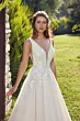 Abito da sposa Robyn Eddy K con dettagli in pizzo, scollo a V, in un giardino soleggiato.