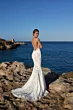 Abito da sposa JASPER di Mark Loren, schiena scoperta, su scogliera con mare sullo sfondo.