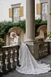 Abito da sposa in pizzo bianco Giulia, Linea Sposae Atelier, su balcone storico con colonne.