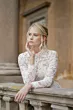 Abito da sposa in pizzo bianco Giulia di Sposae Atelier, donna su balcone antico.