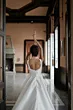Abito da sposa Alchiba Sposae Atelier, vista posteriore in elegante salone, dettagli schiena scoperta.