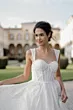 Abito da sposa METEORA di Sposae Atelier, design elegante con dettagli brillanti, sfondo di villa storica.