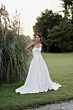 Abito da sposa elegante Capricorn di Sposae Atelier, modello senza spalline, ambientato in un giardino verde.