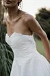 Abito da sposa senza spalline Capricorn di Sposae Atelier, dettagli in pizzo, sfondo naturale.