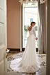 Abito da sposa ONYX di Mark Loren, elegante e scintillante, con strascico, in una stanza luminosa.