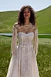 Abito boho SFUMATO - ARIAMO con spalle scoperte e dettagli in pizzo, sfondo collinare verde.