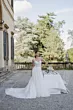 Abito da sposa REBECCA di Sposae in giardino elegante, con dettagli floreali e tavolo decorato.