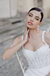 Abito da sposa Rebecca di Sposae, dettaglio del corpetto ricamato e orecchini pendenti.