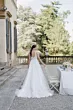 Abito da sposa Rebecca di Sposae, stile romantico, in un giardino elegante con tavola apparecchiata.