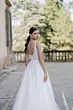 Abito da sposa Rebecca di Sposae, elegante e romantico, con dettagli floreali, sfondo giardino.