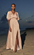 Abito ESSENTIAL 2261 Pronovias, elegante e fluido, indossato su spiaggia al tramonto.