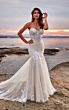 Abito da sposa Isabella di Eddy K, elegante e romantico con dettagli in pizzo, sfondo al tramonto sul mare.