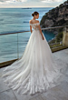 Abito da sposa Sofiane Nicole Jolies con vista mare, elegante design in pizzo e scollo a barca.