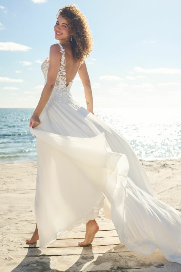 Abito da sposa MAEVE Maggie Sottero in spiaggia, design elegante con dettagli floreali e gonna fluente.
