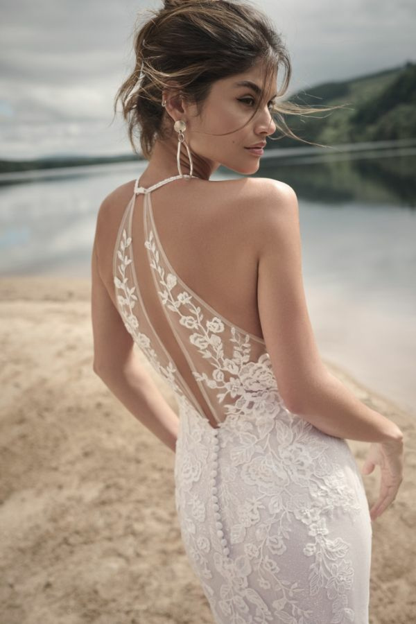 Abito da sposa Maggie Sottero Frost con dettagli in pizzo floreale, scollatura a rete, sfondo lacustre.