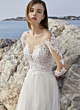 Abito da sposa L1071 Oreasposa, scollo a cuore e pizzo floreale, sfondo marino.