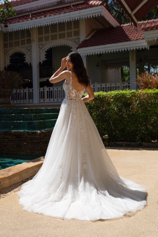 Abito da sposa Amelie Deluxe, schiena scoperta, ambientazione esterna elegante.
