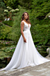 Abito da sposa sambuco in giardino lussureggiante, dettagli in pizzo e gonna ampia.