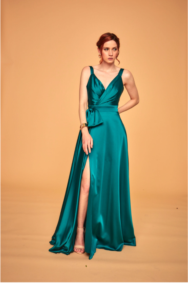 Abito elegante verde smeraldo con spacco, modello LPA242 LINEA LE PREZIOSE, sfondo beige.