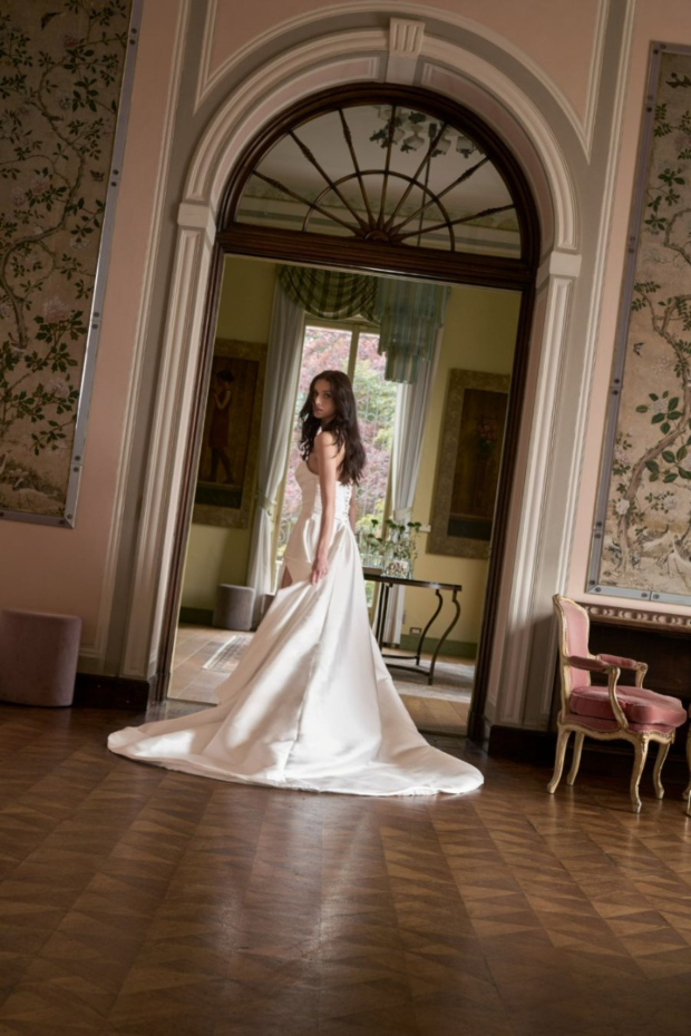 Abito da sposa elegante in seta bianca, collezione Romantica, in ambiente classico con arredi raffinati.
