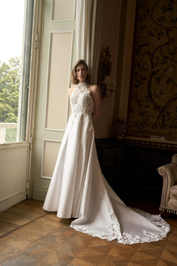 Abito da sposa Orietta, collezione Romantica, con pizzo e strascico, in elegante salone con finestra.